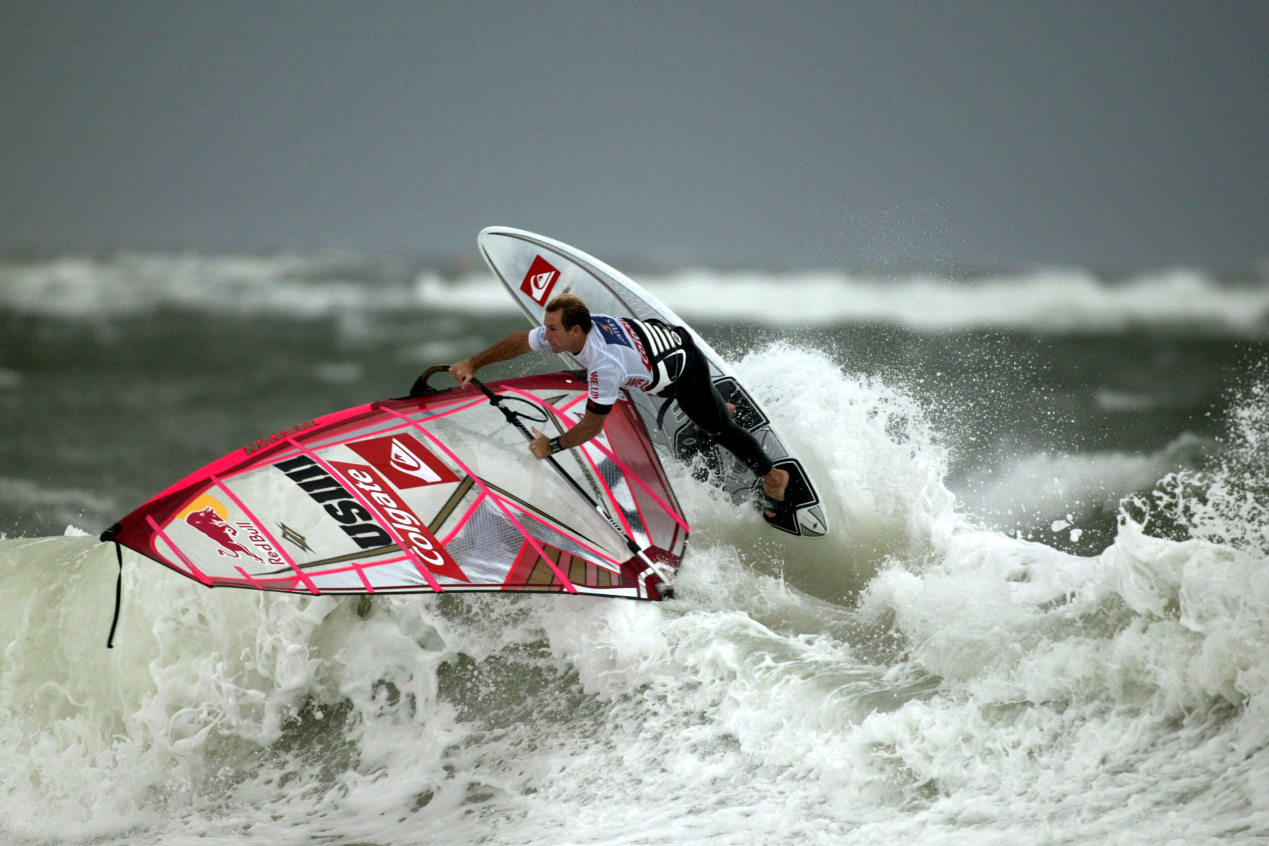 Robby Naish wykonuje manewr na desce windsurfingowej na wzburzonej fali podczas World Cup Sylt w Niemczech w 2006 roku. Zdjęcie poglądowe.
